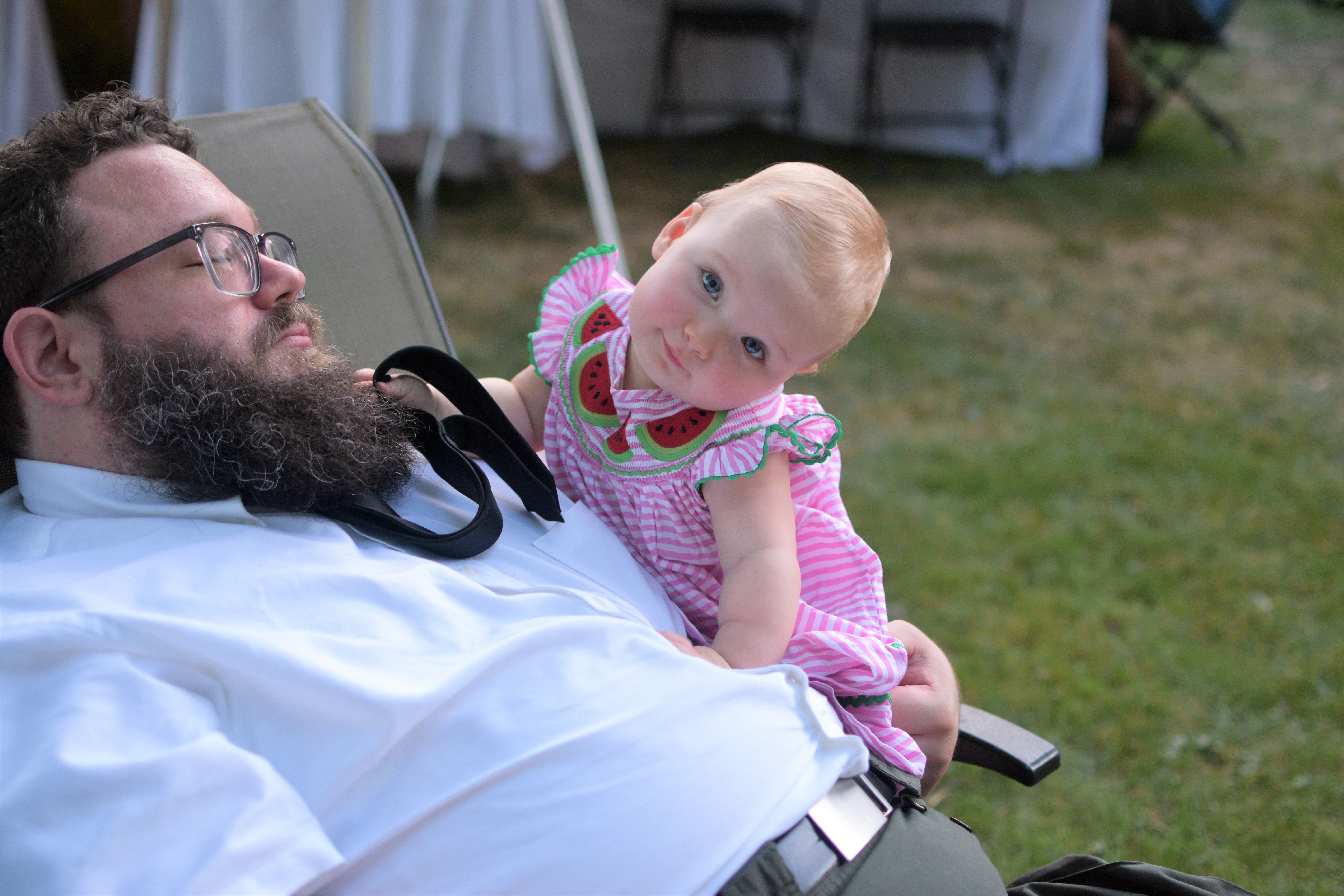 baby tilting head while climbing on dad's stomach