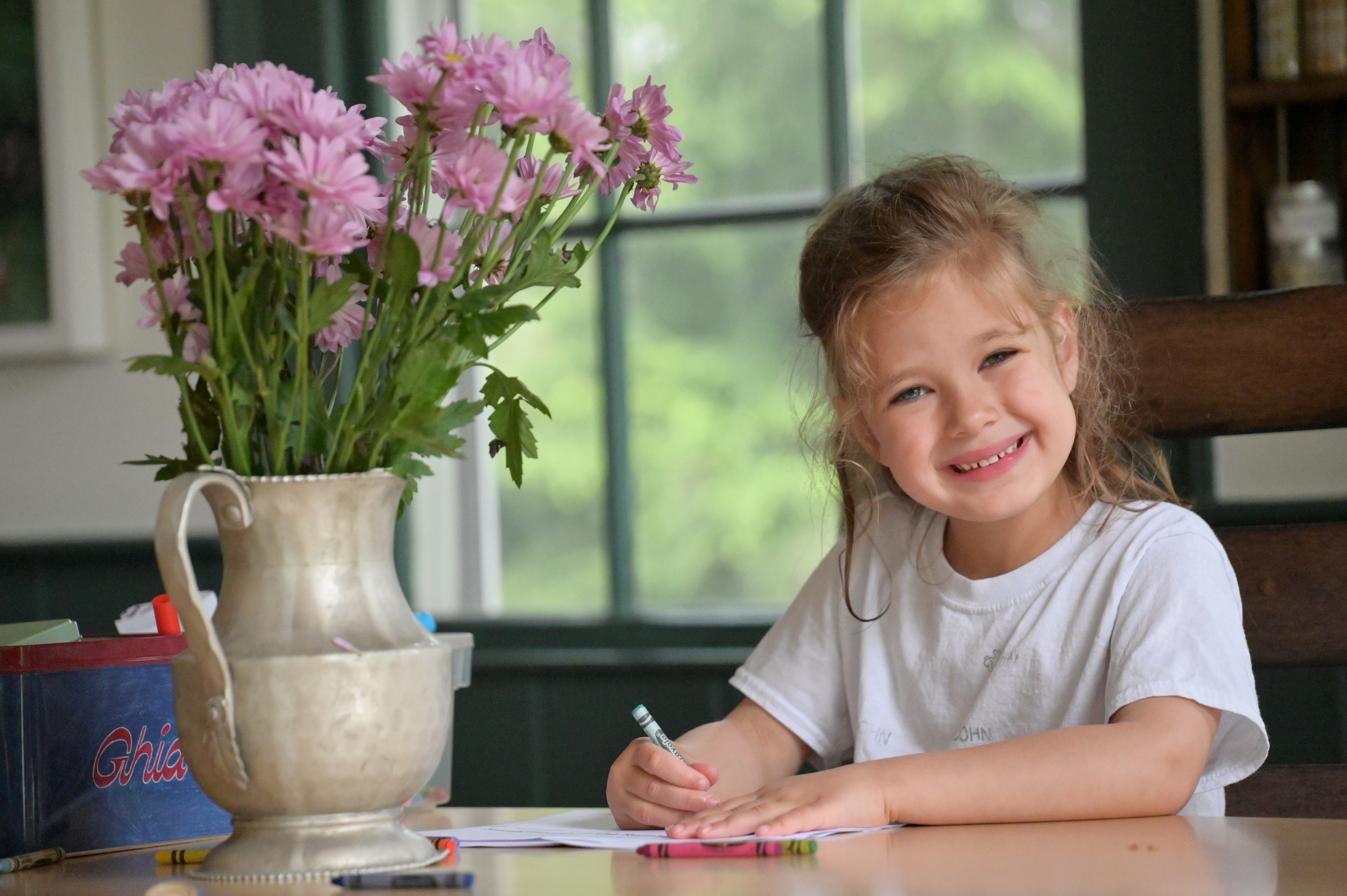 5 year old coloring next to flowers