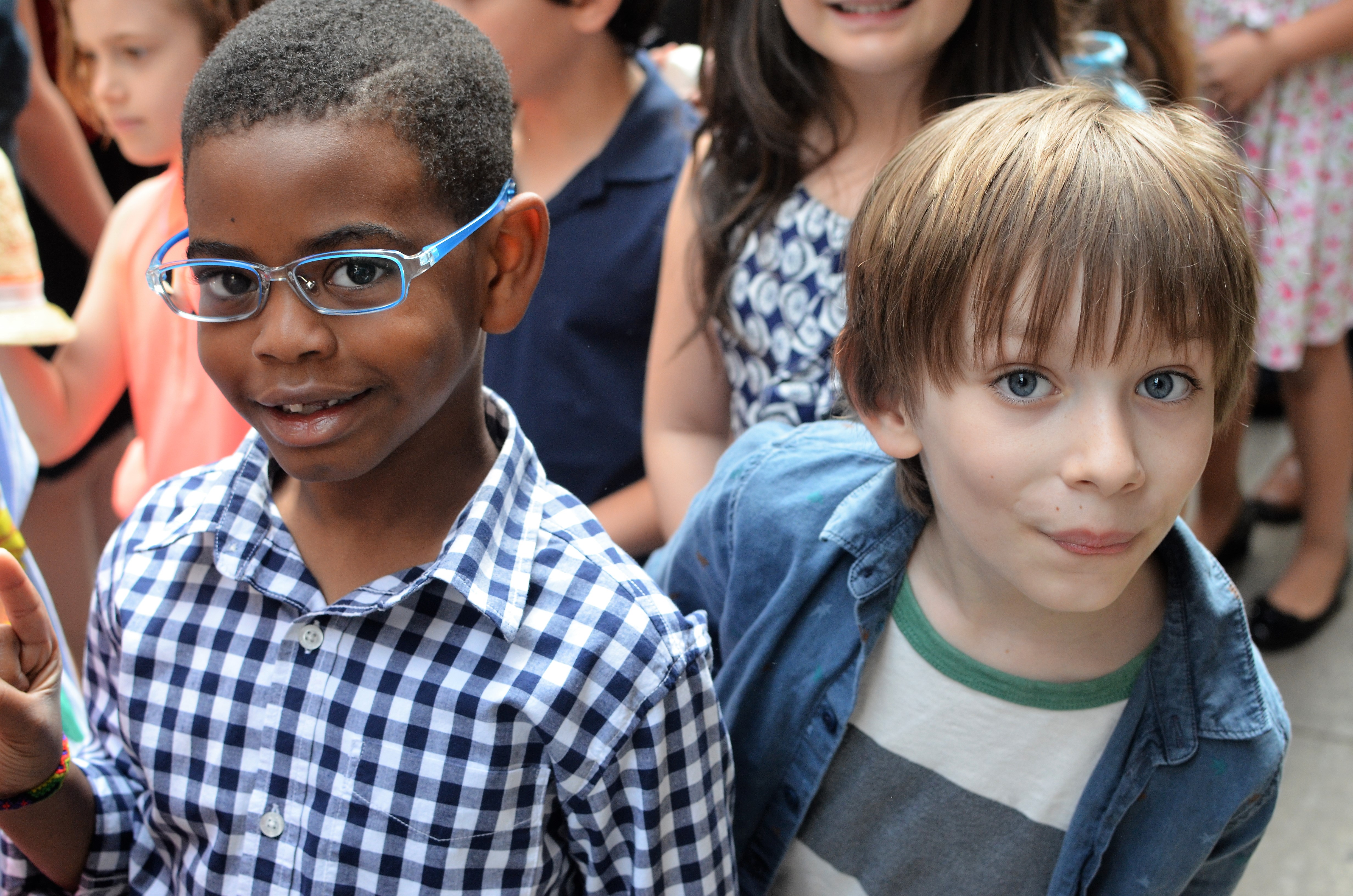 two boys, different races, smiling for camera